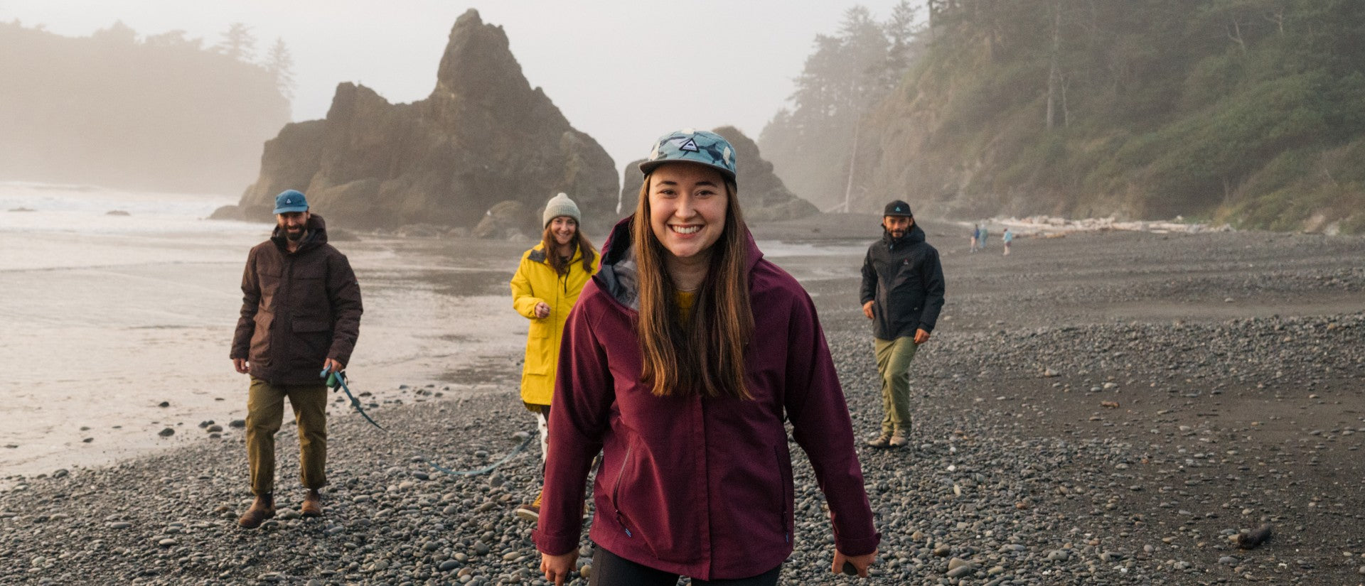 A group stood on a beach in the PNW, smiling at the camera