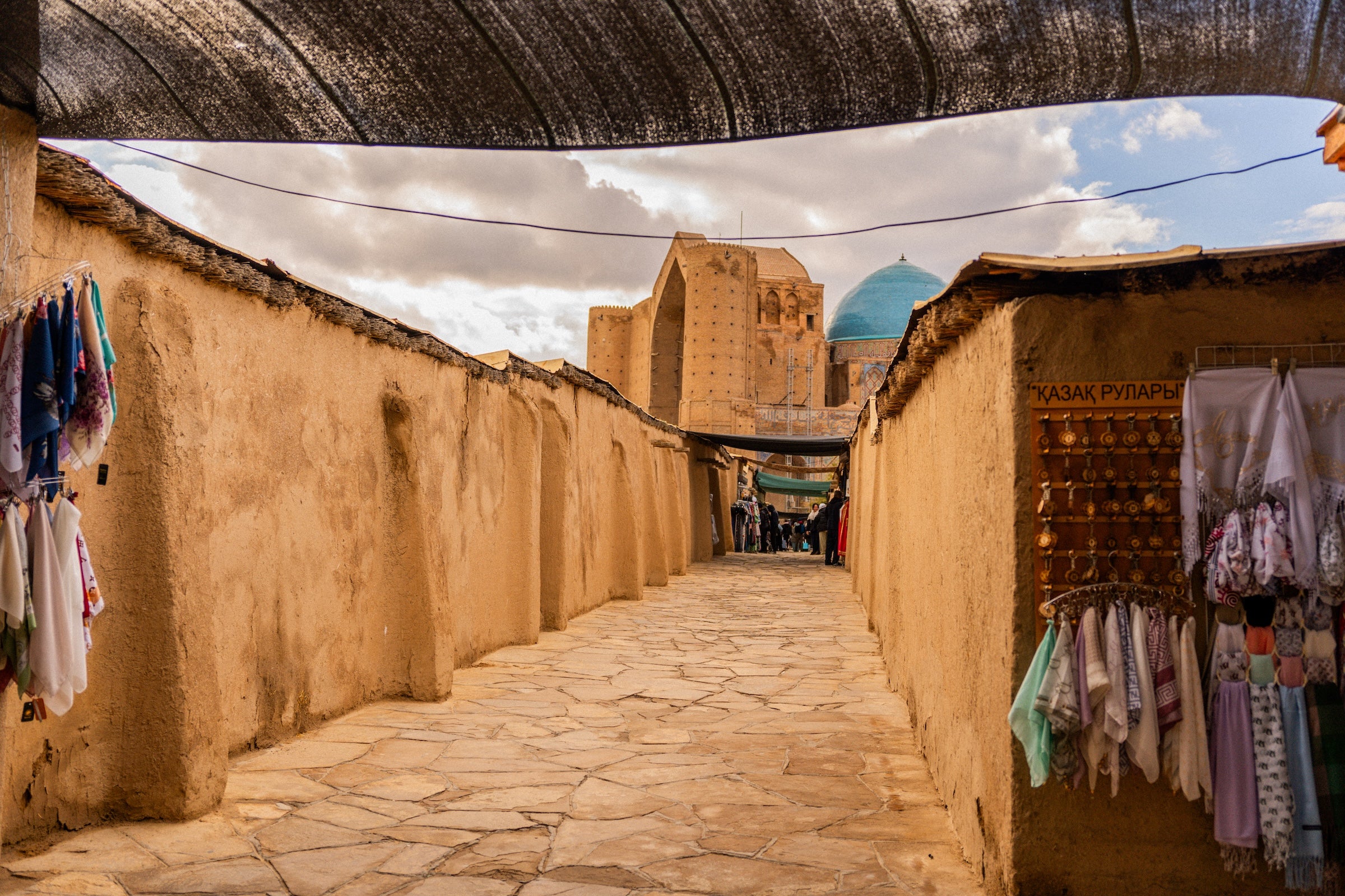 narrow street with shops and a building with a dome in the background